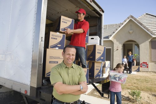 Professional movers carrying household items during a Purley move